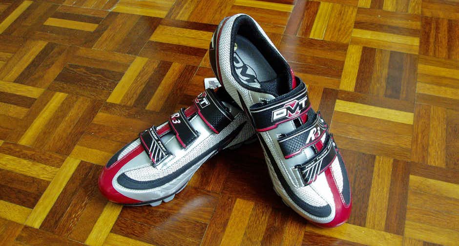 A pair of brand new DMT RS3 cycling shoes carefully placed on a wooden tile floor A pair of brand new DMT RS3 cycling shoes carefully placed on a wooden tile floor